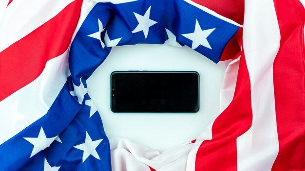 Foto amerikanischer flaggenhintergrund mit smartphone.