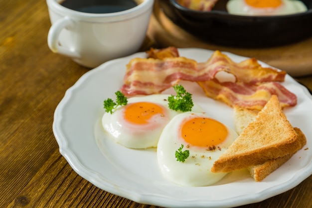 Foto amerikanisches frühstück mit spiegeleiern, speck, toast, pfannkuchen, kaffee und saft