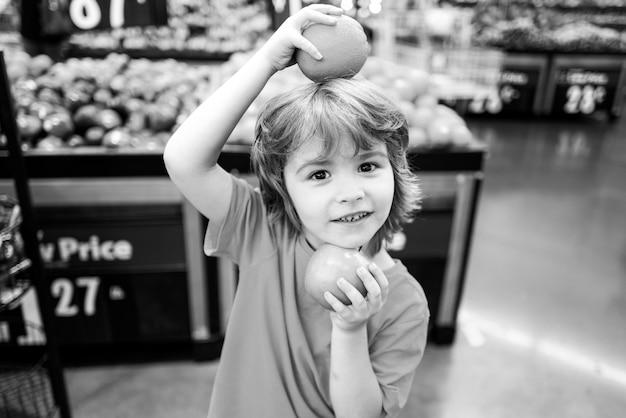 Amerikanisches Kind mit Einkaufswagen beim Einkaufen im Supermarkt Supermarkt mit Kind