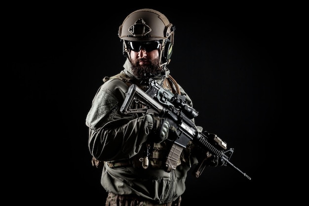 Amerikanisches Kommando in einer Militäruniform mit einer Waffe betrachtet den Kopierraum