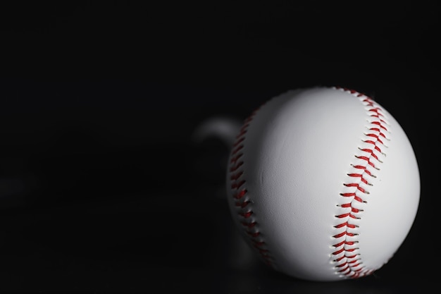 Amerikanisches traditionelles Sportspiel. Baseball. Konzept. Baseballball und Schläger auf einem schwarzen Tisch.