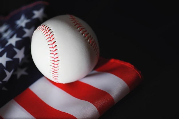 Amerikanisches traditionelles Sportspiel. Baseball. Konzept. Baseballball und Schläger auf einem Tisch mit amerikanischer Flagge.