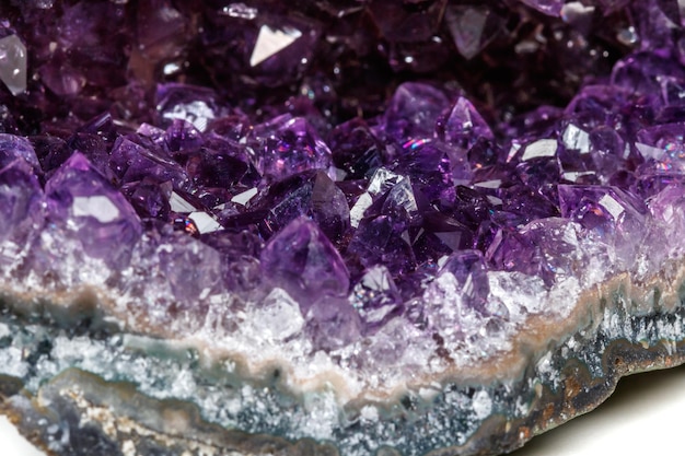 Ametistas de pedra mineral macro na rocha em um fundo branco