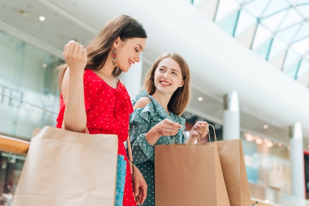 Foto amigas de bajo ángulo en el centro comercial