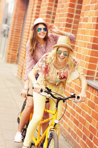 amigas en bicicleta tándem en la ciudad