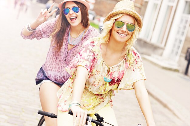 amigas en bicicleta tándem en la ciudad