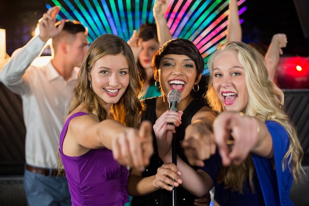 Amigas cantando canciones juntos en el bar