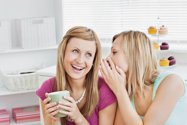 Amigas cercanas hablando con una taza de café en casa