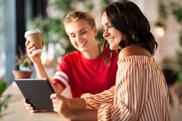 amigas com tablet PC e café no café