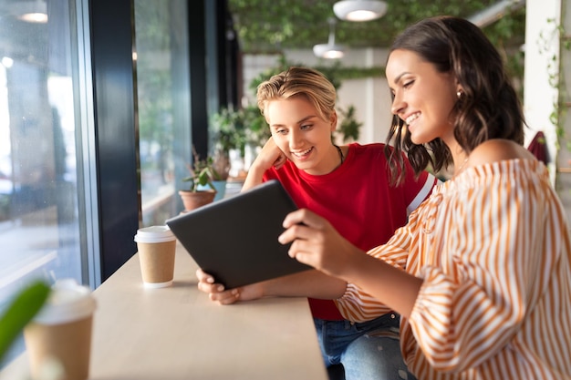 amigas com tablet PC e café no café