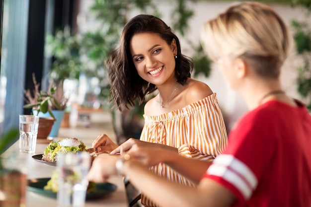 Foto amigas comiendo en un restaurante.