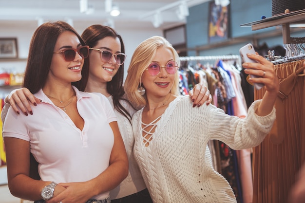 Amigas de compras juntas en la tienda de ropa