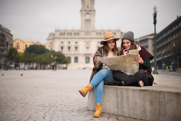 Amigas consultando un mapa de la ciudad en invierno