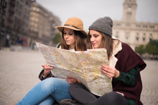 Amigas consultando um mapa da cidade no inverno