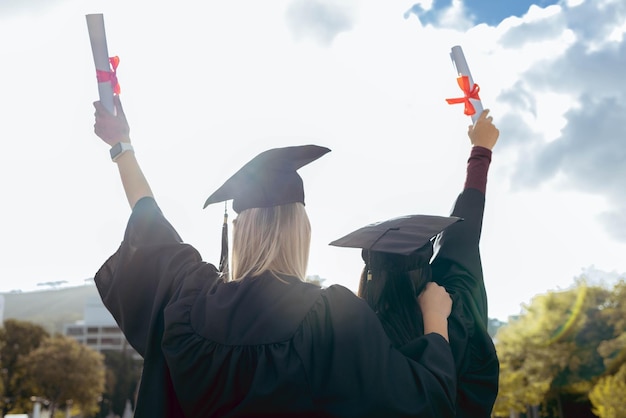 Amigas de formatura e certificado com costas para celebração felicidade ou sucesso por estudarem juntas Estudante universitária negra e diversidade para visão de objetivo e apoio no campus