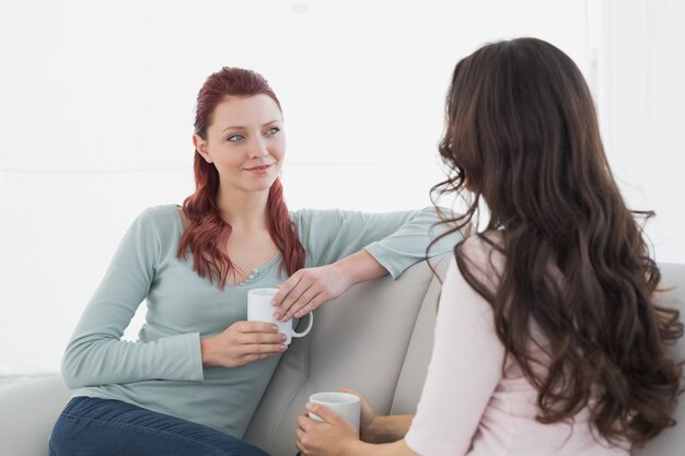 Amigas disfrutando de una charla tomando un café en casa