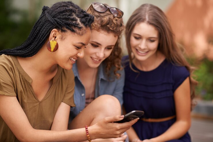 Foto amigas e felizes com celular ao ar livre nas mídias sociais para memes entretenimento e tendências diversidade amizade e quebrar com o serviço de streaming e navegar na internet para internet gif