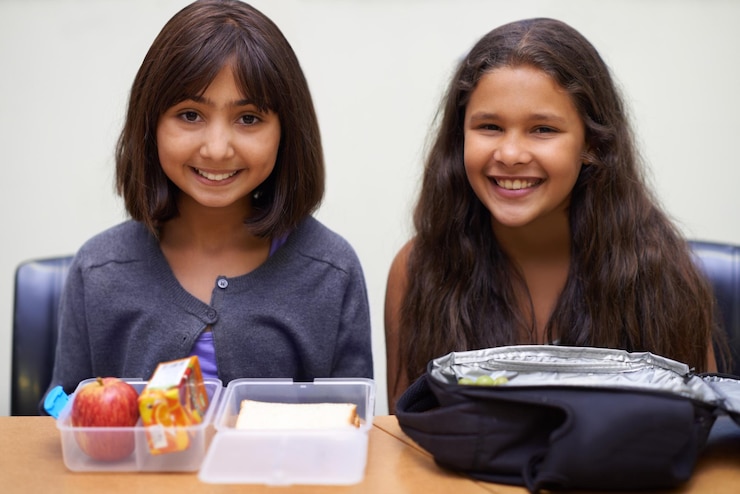 Foto amigas e retrato com almoço na escola para o recesso ou nutrição na mesa e feliz crianças rosto e sorriso na academia ou relaxar com confiança comida ou orgulho para o desenvolvimento da infância