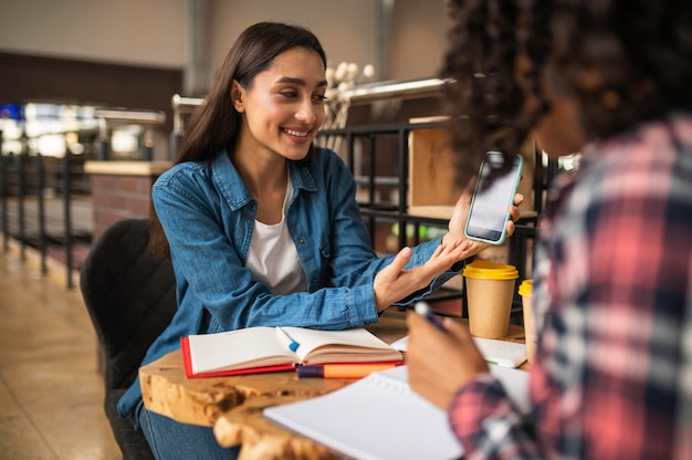 Amigas fazendo lição de casa juntas no café