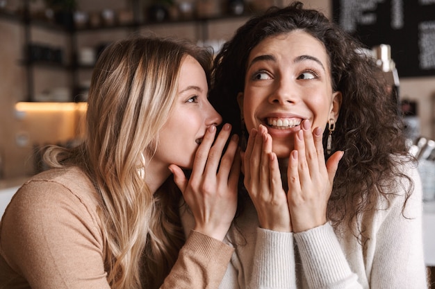 amigas felizes sentadas em um café conversando e fofocando