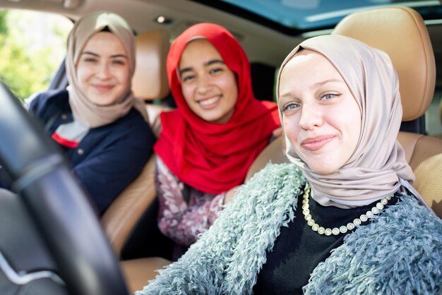 Amigas muçulmanas curtindo a viagem viajando de férias no carro. foto de alta qualidade