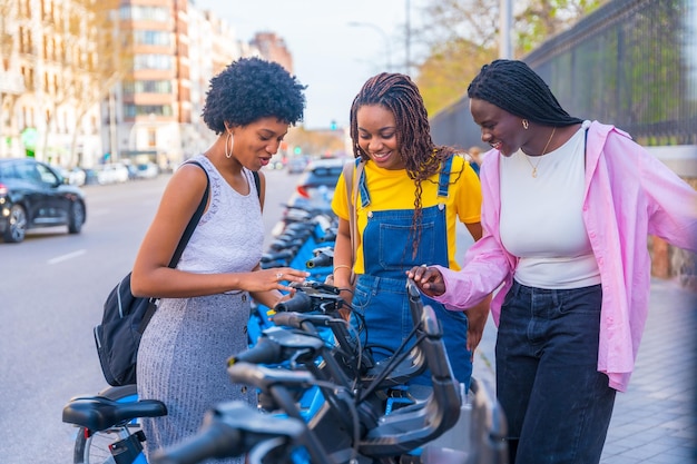 Amigas multirraciales que usan el sistema de bicicletas públicas