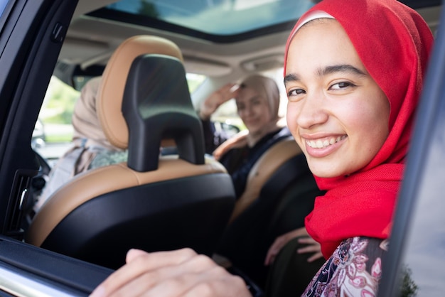 Amigas musulmanas disfrutando de un viaje por carretera viajando de vacaciones en el coche foto de alta calidad