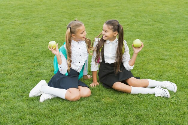 Amigas pequenas comem merenda escolar saudável, conceito de infância feliz.