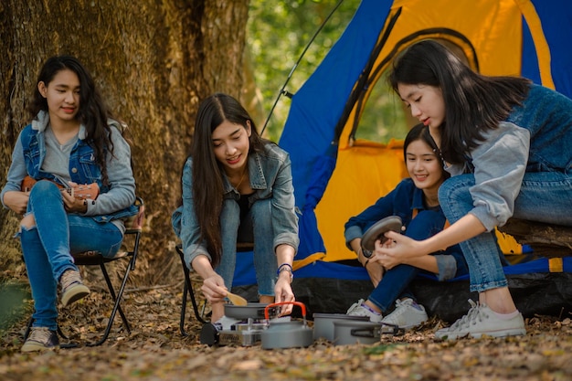 Foto amigas preparando comida durante el campamento