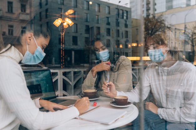 Las amigas que se conocieron en un café usan máscaras protectoras médicas