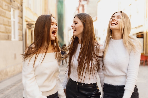 Amigas riendo caminando por las calles de la ciudad