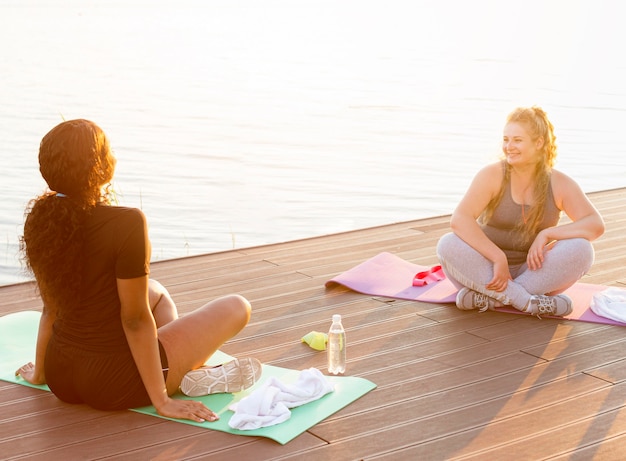 Amigas se exercitando à beira do lago