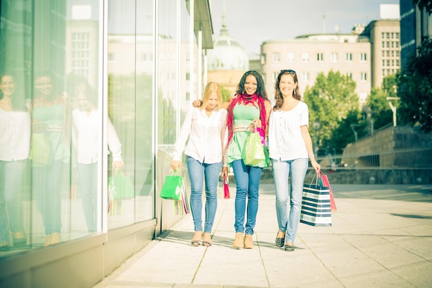Amigas de toda la longitud afuera del edificio en la pasarela durante un día soleado