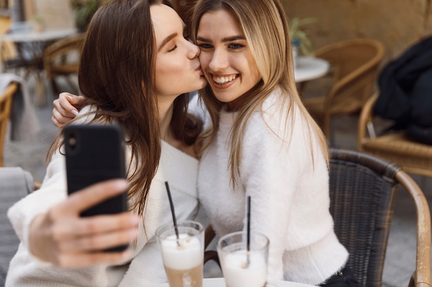 Amigas tomando una selfie en una mesa de café