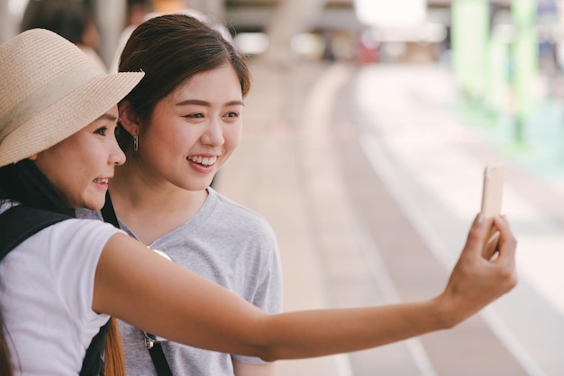 Amigas tomando selfies mientras están de pie en la acera