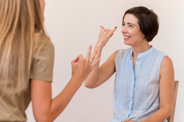 Foto amigas usando lenguaje de señas para hablar entre sí