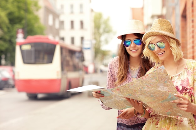 amigas usando un mapa en la ciudad