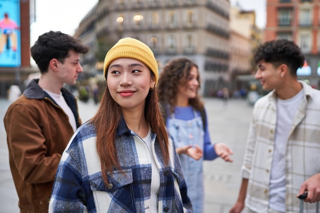 Amigo chinês radiante de felicidade enquanto grupos diversos conversam e riem ao fundo