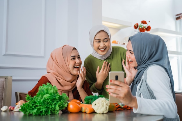 Amigo com hijab olhando para o telefone para fazer comida
