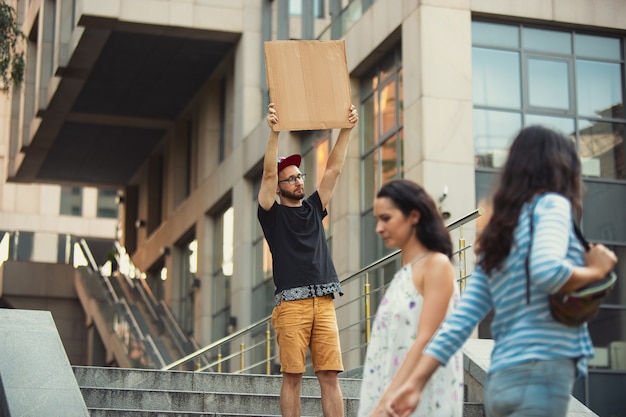 Amigo con letrero: el hombre está de pie protestando por las cosas que lo molestan. Demostración en solitario de su derecho a hablar libremente en la calle con cartel. Copyspace para texto. Opinión escuchada por el público. Vida social, humor, meme.