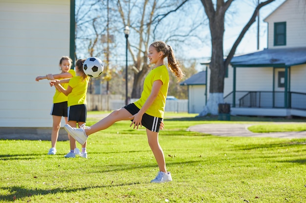 Amigo meninas adolescentes jogando futebol futebol em um parque