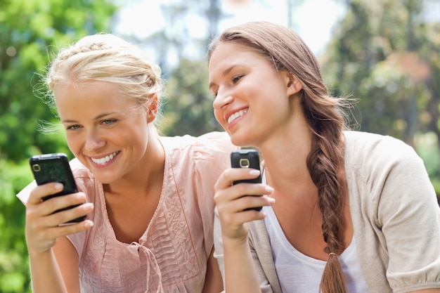 Amigo sonriente con teléfonos celulares