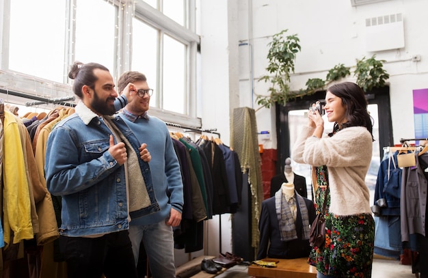 amigos a fotografar numa loja de roupas antigas.