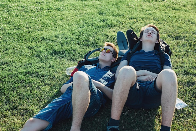 Foto amigos a relaxar no campo gramado.