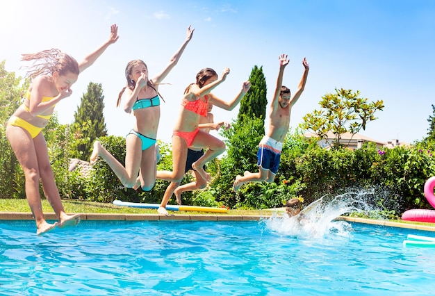 Foto amigos a saltar na piscina.