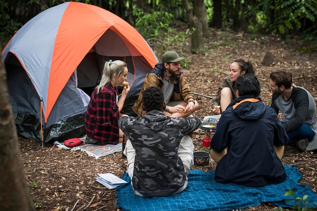 Amigos acampando en el bosque juntos