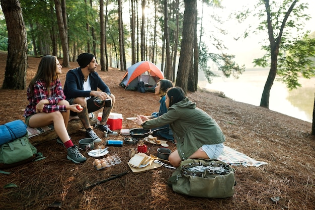 Amigos acampando comiendo comida concepto