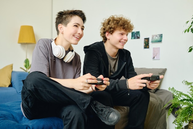 Amigos adolescentes alegres ou encontros com gamepads jogando videogames