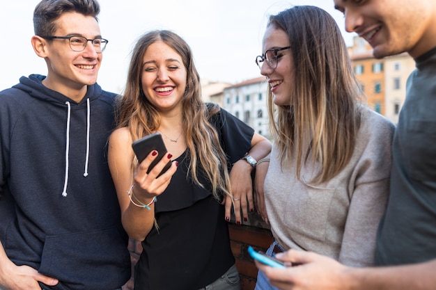 Amigos adolescentes com smartphones rindo e se divertindo