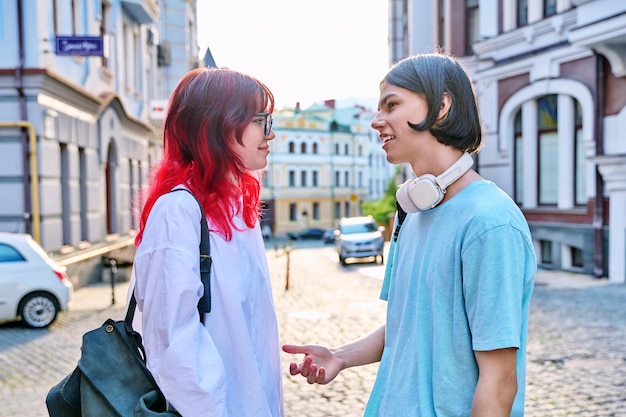 Amigos adolescentes hombre y mujer hablando en la calle de la ciudad a la moda divirtiéndose adolescentes chico y chica juntos al aire libre amistad comunicación vacaciones estilo de vida juventud estilo urbano